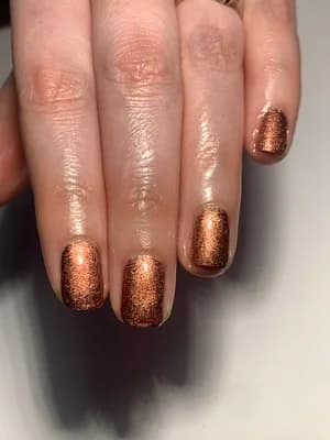 Short nails coated in dense copper and bronze glitter with sparkling finish.