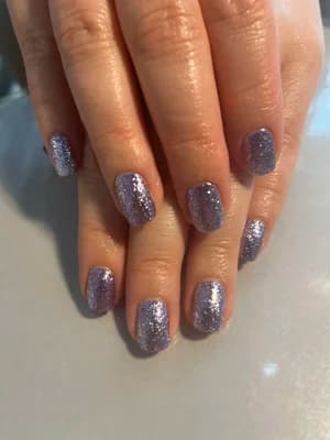 Short square nails in lavender-mauve polish with fine silver glitter throughout.
