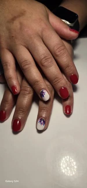 Glossy solid red nails with white accent nails showing purple firework floral spikes.