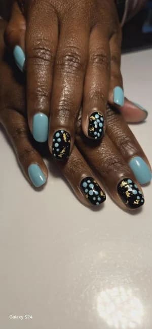 Baby blue nails paired with black accents dotted in white and gold foil.