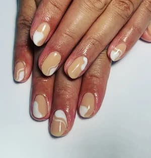 Short nude beige nails with abstract white swirling wave line designs.