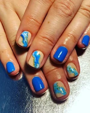 Short nails alternating solid blue and nude with turquoise marble swirls and gold flecks.
