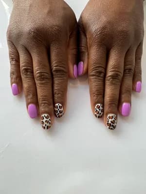 Bright orchid purple solid nails paired with tan leopard animal print accent nails.