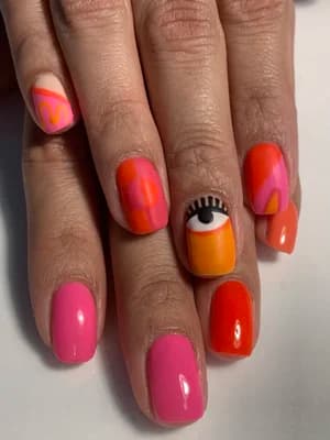 Pink and orange abstract swirl nails with an orange and yellow eye design accent.