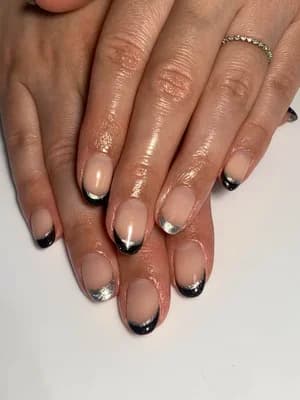 Sheer nude nails with black and silver chrome French tips, rounded shape.
