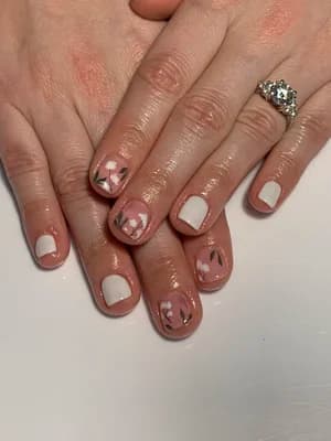 Sheer nails with negative space cuticle line and soft pink marble floral accents.