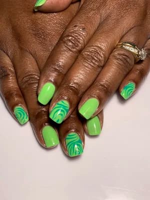 Bright lime green nails with darker green swirled wave patterns on accent nails.