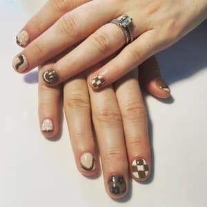 Short neutral taupe and beige nails with swirls, checkerboard, and leopard animal-print accents