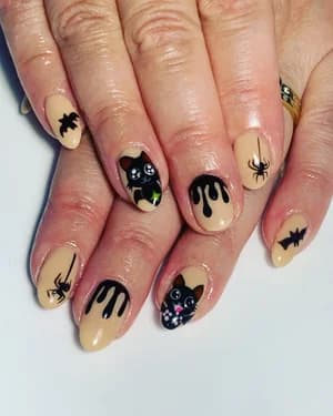 Nude beige nails with black Halloween art: dripping paint, cat, spiders and bats