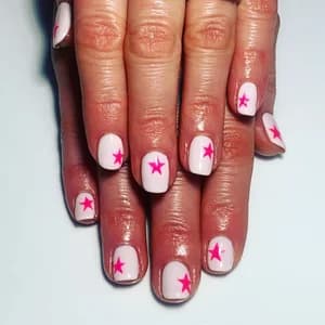 Short pale pink and white nails with bright magenta star cutout designs