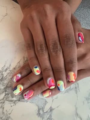 Short nails with abstract pastel blobs and swirls in blue, pink, red and yellow