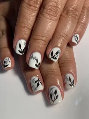White nails with black and metallic silver leaf branch line art across each nail