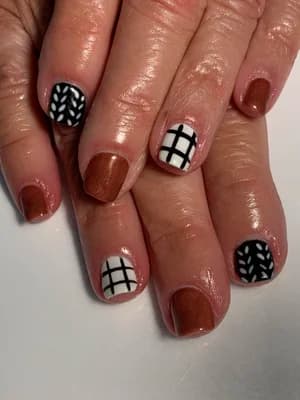 Short nails alternating copper shimmer with black-and-white plaid grid and leaf line accents