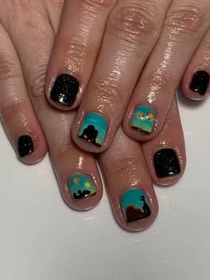 Black glitter and turquoise nails with painted sunset landscape silhouettes and small sun accents