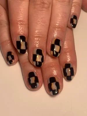 Black, cream and beige patchwork checkerboard design with metallic gold squares on short nails