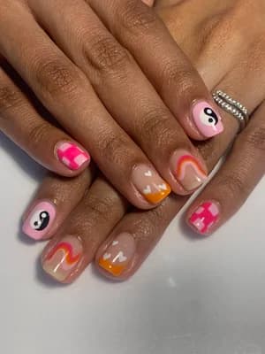 Pink, orange and nude retro nails featuring yin-yang symbols, wavy swirls and checkerboard accents