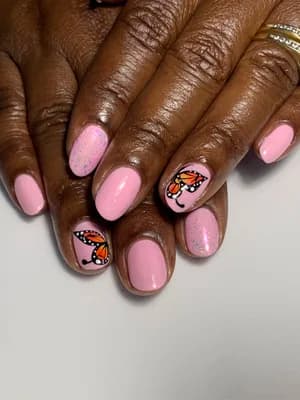 Glittery pink nails with hand-painted orange and black monarch butterfly accent designs