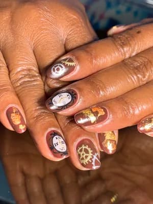 Copper and bronze chrome nails with steampunk gears, clock faces, and gold foil accents.