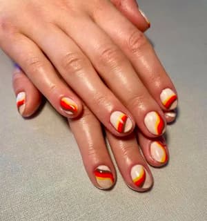 Short nude nails with abstract red, yellow, and cream swoosh line-art shapes.