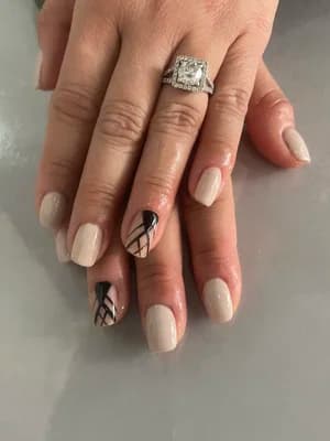 Cream nude nails with black-and-white accent nails featuring abstract crosshatch line work geometric patterns