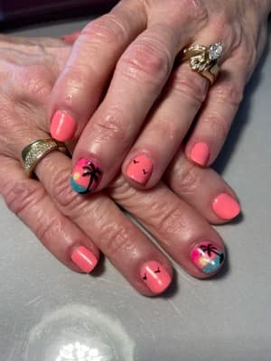 Coral pink nails with tropical sunset scene: palm tree silhouettes, birds, blue-pink ombre beach